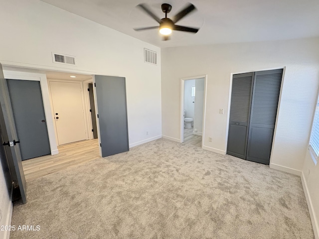 6419 W Monte Cristo Ave, Glendale, AZ 85306 - unfurnished bedroom with light colored carpet, baseboards, ensuite bath, vaulted ceiling, and a ceiling fan