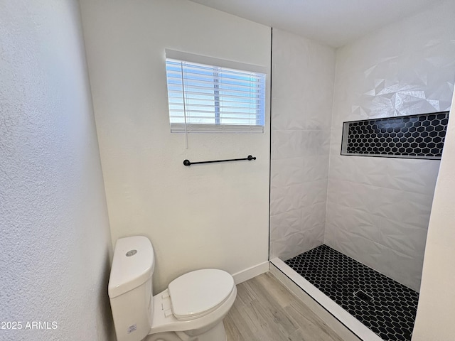 6419 W Monte Cristo Ave, Glendale, AZ 85306 - bathroom featuring a tile shower, wood finished floors, and toilet