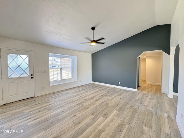 6419 W Monte Cristo Ave, Glendale, AZ 85306 - entryway with a ceiling fan, arched walkways, light wood-style floors, vaulted ceiling, and baseboards