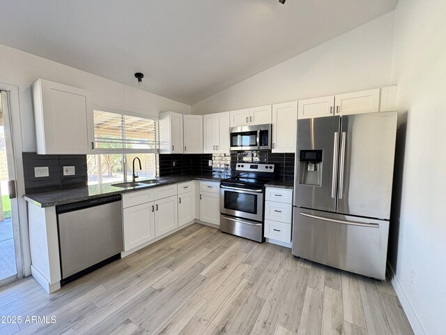 6419 W Monte Cristo Ave, Glendale, AZ 85306 - kitchen featuring appliances with stainless steel finishes, a sink, lofted ceiling, white cabinetry, and tasteful backsplash