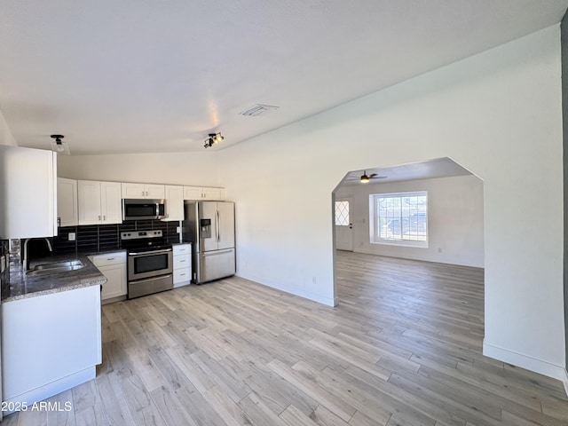 6419 W Monte Cristo Ave, Glendale, AZ 85306 - kitchen featuring appliances with stainless steel finishes, a sink, open floor plan, backsplash, and light wood-style floors