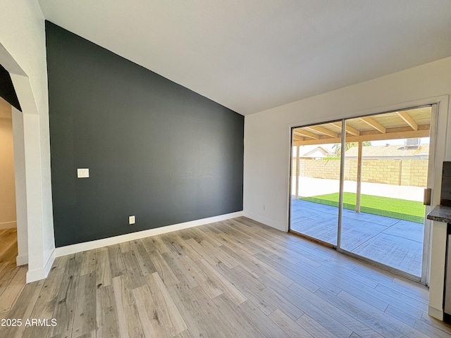 6419 W Monte Cristo Ave, Glendale, AZ 85306 - empty room featuring light wood-type flooring, vaulted ceiling, and baseboards