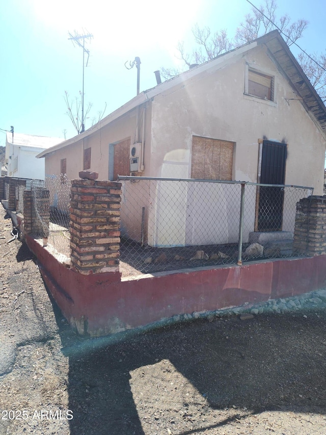 exterior space with stucco siding and fence