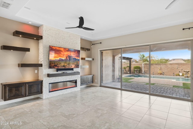 unfurnished living room with a fireplace, light tile patterned floors, and ceiling fan