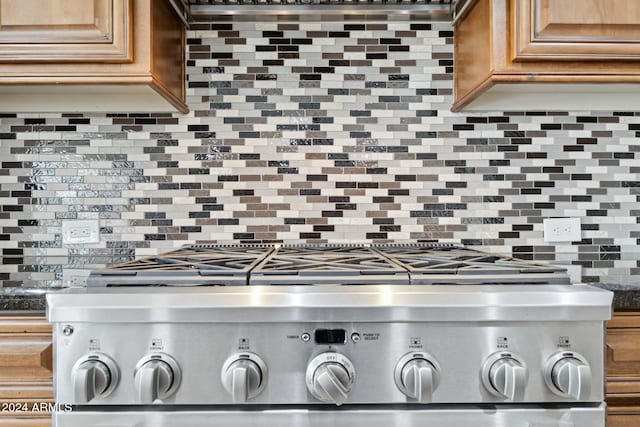 details featuring stainless steel range and backsplash