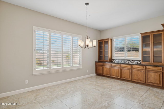 unfurnished dining area with a notable chandelier and light tile patterned flooring