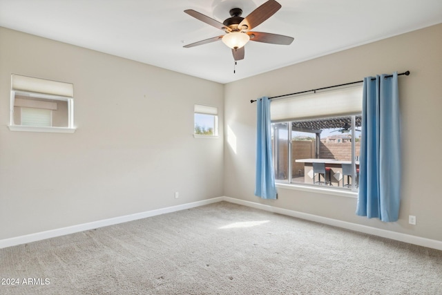 carpeted empty room featuring a wealth of natural light and ceiling fan