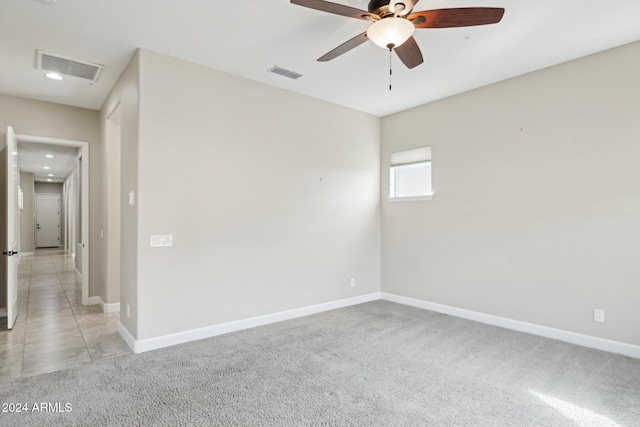 carpeted spare room featuring ceiling fan