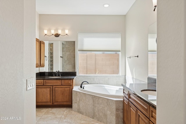 bathroom featuring tile patterned floors, tiled tub, and vanity