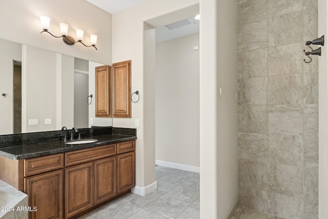 bathroom featuring tile patterned floors, vanity, and tiled shower