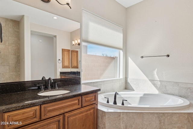 bathroom with vanity and tiled bath