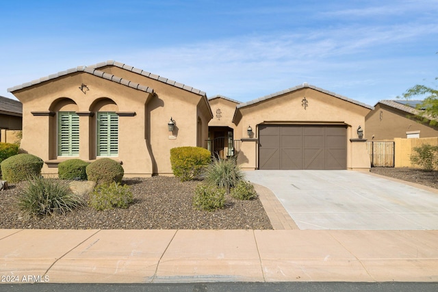 12860 W Calle De Sol, Peoria, AZ 85383 - mediterranean / spanish-style home featuring a gate, concrete driveway, stucco siding, an attached garage, and a tiled roof