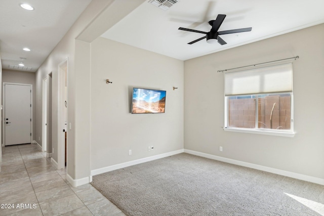 spare room featuring ceiling fan and light colored carpet