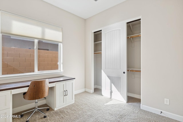 unfurnished office with built in desk and light colored carpet