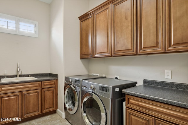 laundry area with cabinets, light tile patterned floors, washing machine and clothes dryer, and sink