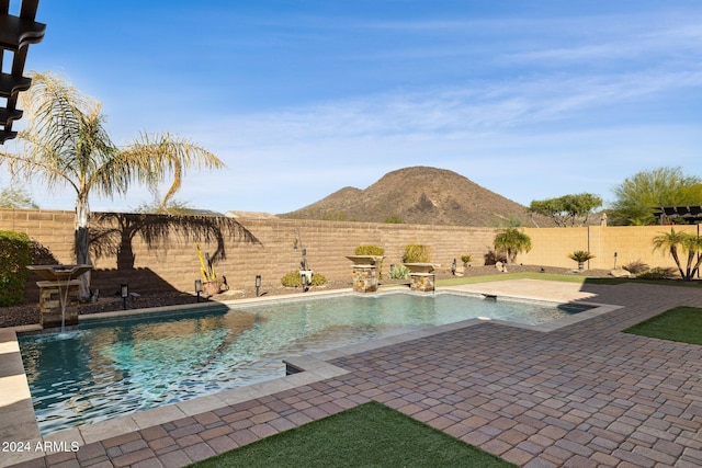 view of swimming pool with pool water feature and a patio