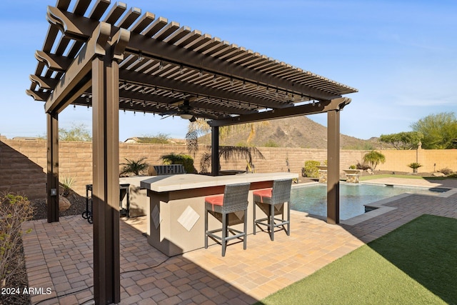 view of patio / terrace with a pergola, a bar, and a fenced in pool