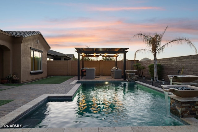 pool at dusk with pool water feature, a pergola, and a patio