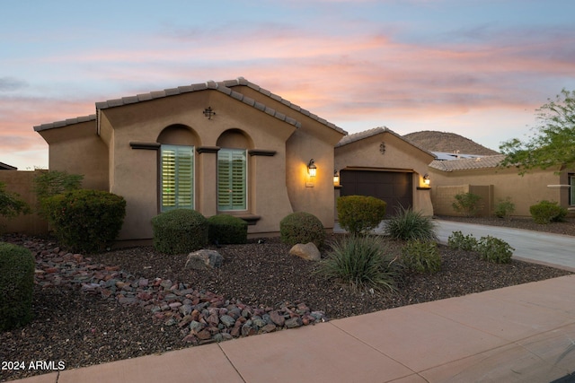 12860 W Calle De Sol, Peoria, AZ 85383 - mediterranean / spanish home with concrete driveway, an attached garage, stucco siding, and a tiled roof
