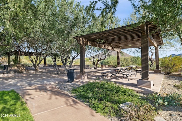 view of community featuring a mountain view and a pergola