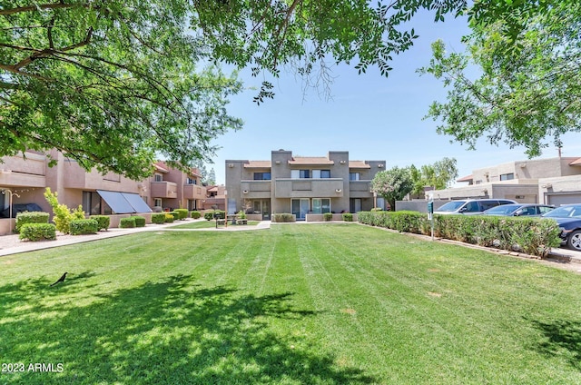 view of front of home featuring a balcony and a front yard