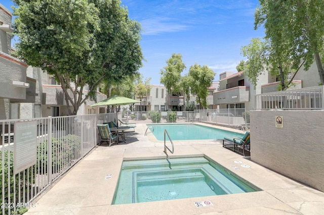 view of swimming pool featuring a patio area and a hot tub