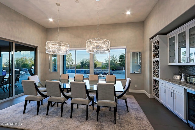 dining room with bar, dark tile patterned floors, beverage cooler, and a notable chandelier