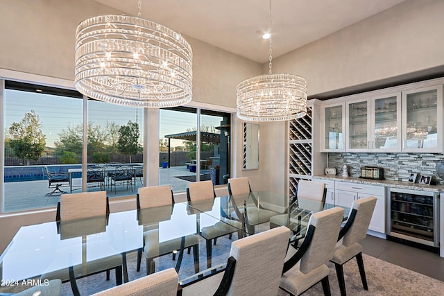 dining space featuring indoor bar, wine cooler, and an inviting chandelier