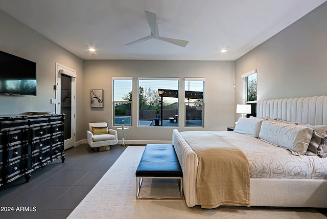 tiled bedroom with ceiling fan and multiple windows