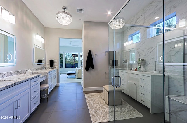 bathroom with a chandelier, vanity, tile patterned floors, and a shower with door