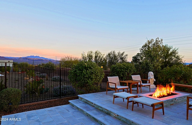 patio terrace at dusk with a mountain view and an outdoor fire pit