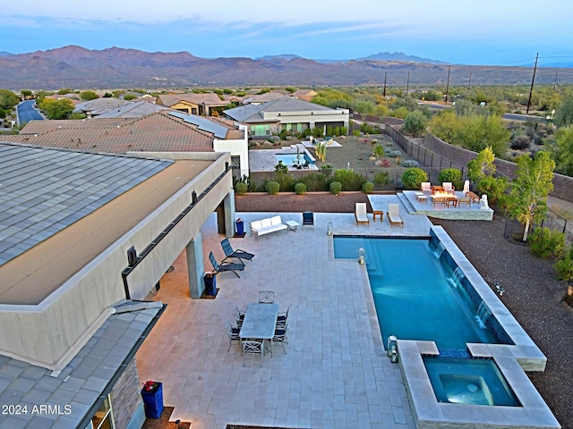 view of swimming pool with a mountain view, an in ground hot tub, and a patio area