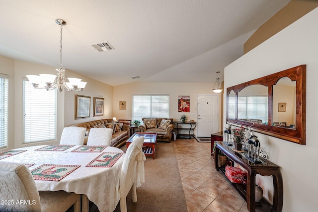 tiled dining space with lofted ceiling and an inviting chandelier