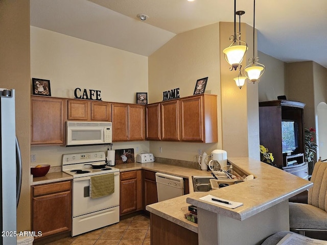 kitchen with white appliances, kitchen peninsula, sink, and hanging light fixtures