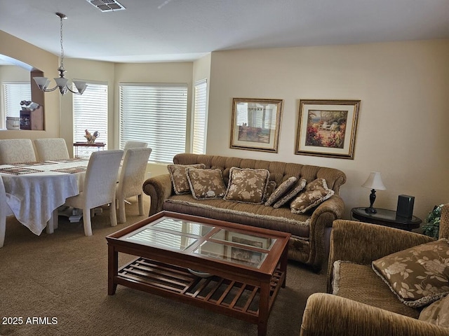 carpeted living room with a chandelier