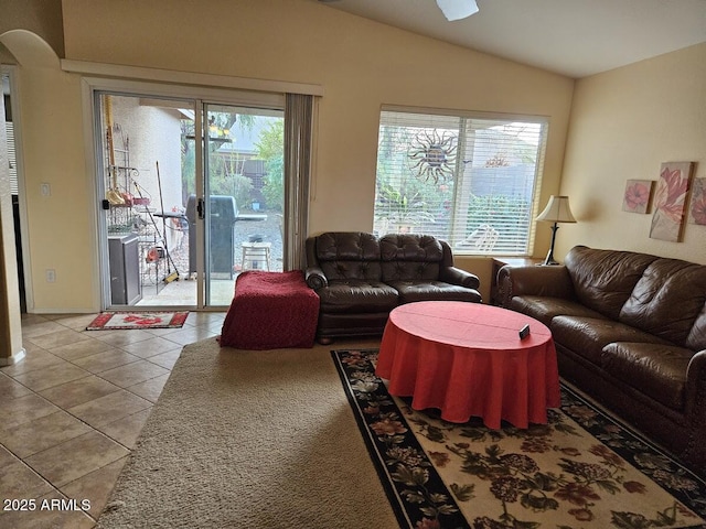 living room featuring vaulted ceiling, plenty of natural light, and tile patterned floors