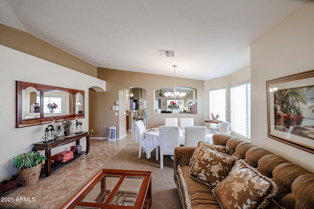 tiled living room with a chandelier and a textured ceiling