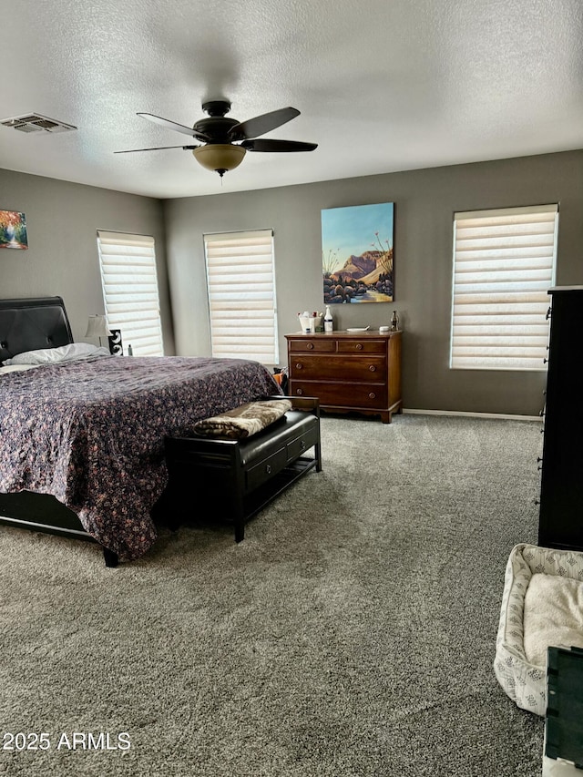 carpeted bedroom featuring visible vents, ceiling fan, and a textured ceiling
