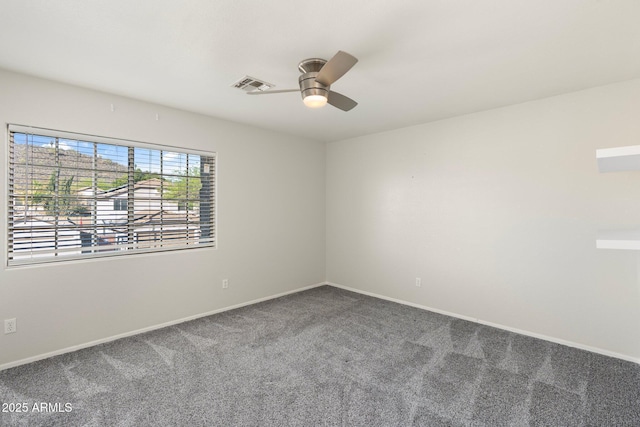 spare room with visible vents, ceiling fan, carpet, and baseboards