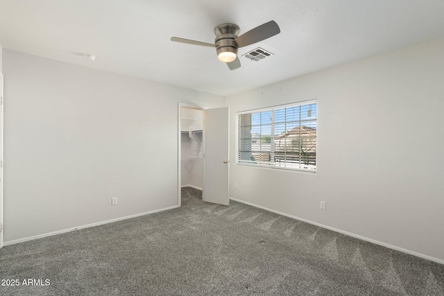 unfurnished bedroom with carpet flooring, baseboards, a spacious closet, and visible vents