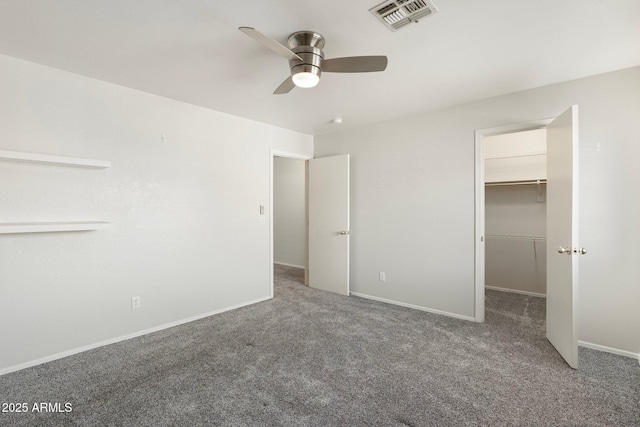unfurnished bedroom with visible vents, a spacious closet, carpet, and baseboards
