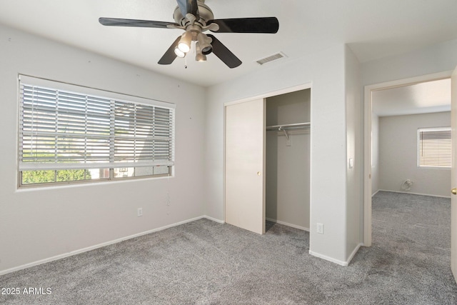 unfurnished bedroom featuring baseboards, a closet, a ceiling fan, carpet floors, and visible vents