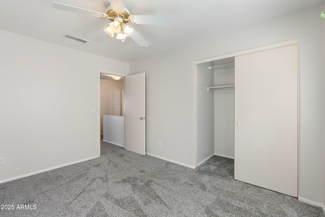 unfurnished bedroom with carpet, a closet, a ceiling fan, visible vents, and baseboards