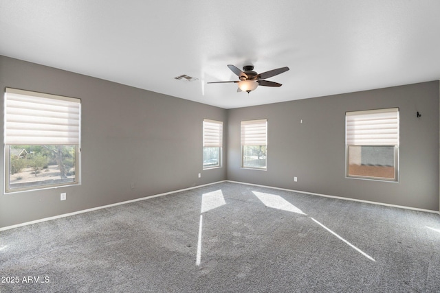 spare room with baseboards, a ceiling fan, visible vents, and carpet floors