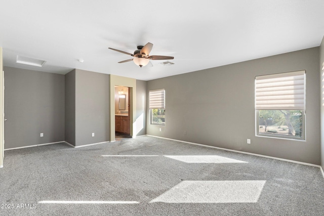 carpeted empty room with baseboards, a ceiling fan, and visible vents
