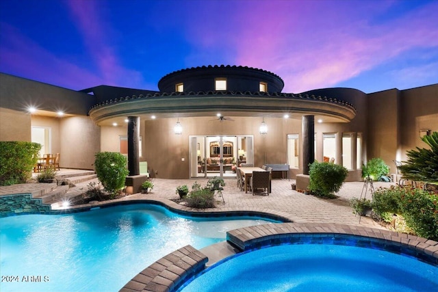 pool at dusk with french doors, ceiling fan, an in ground hot tub, and a patio area