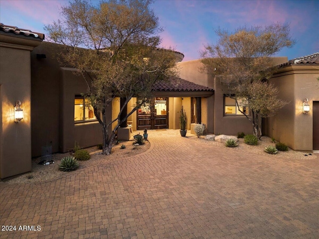 pueblo revival-style home featuring a patio area