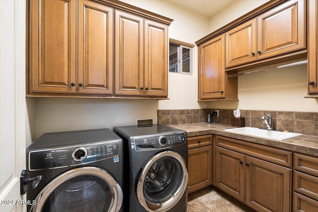 washroom featuring cabinets, washing machine and dryer, and sink