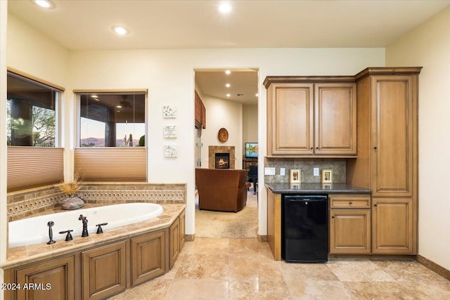 interior space with black dishwasher, dark stone counters, and backsplash