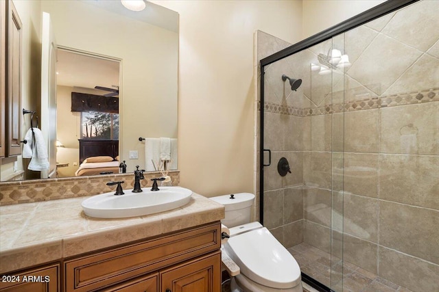 bathroom with vanity, toilet, and a shower with shower door